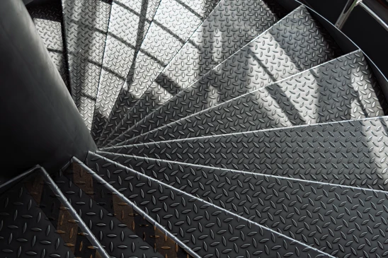 Intérieur moderne avec escalier suspendu à structure métallique noire et marches en bois massif